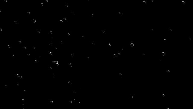 Rare air bubbles slowly rise up against a black screen.