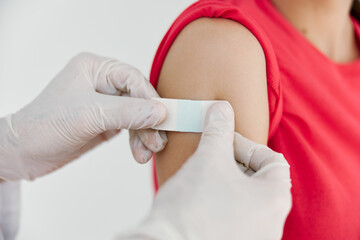 a doctor in medical gloves seals his hand with adhesive tape after injection close-ups