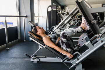 woman in gym performing leg exercises on press
