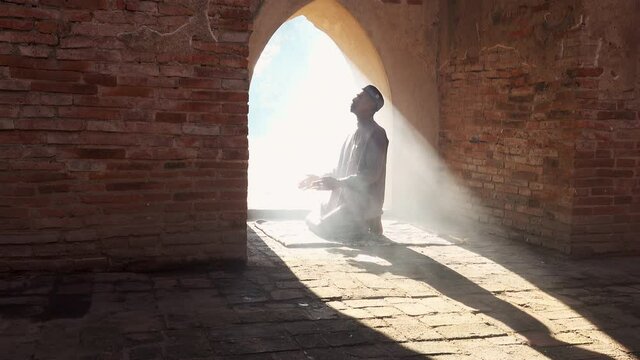Muslim man praying at an old mosque Has a smoke background in Phra Nakhon Si Ayutthaya Province, Thailand, Asian Muslims