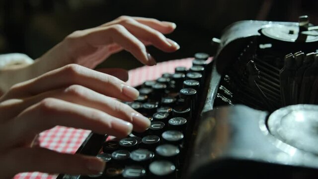 Secretary at old typewriter. Business concepts. Retro. Pensive hands typing