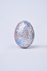 Silver shiny painted egg on white background.