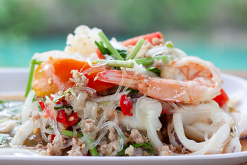 Closeup Spicy vermicelli salad in white plate at restaurant.