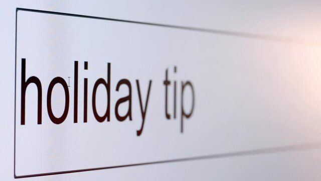 Search bar on a computer monitor with the question Holiday tip. Searching for information on the Internet, close up.