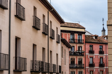 Fototapeta na wymiar Old Traditional Residential Buildings in Central Madrid. Colorful Facades Against Cloudy Sky