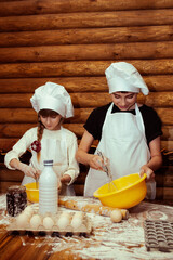 Brother and sister knead dough together. Family traditions. Baking process. Wooden background.