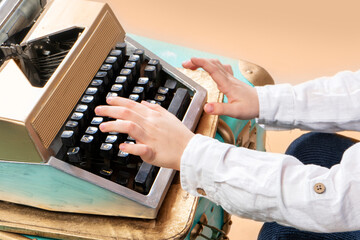 Close-up hands of boy typing on classic typewriter