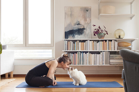 Woman and cat booping noses together during workout
