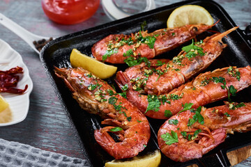 Grilled large queen shrimps with lemon and spices on the grill pan