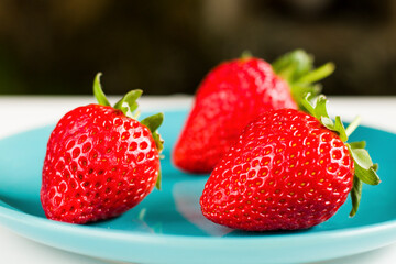 Strawberry on the blue background, raw real strawberry
