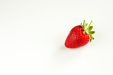 One strawberry on the white background, raw real strawberry