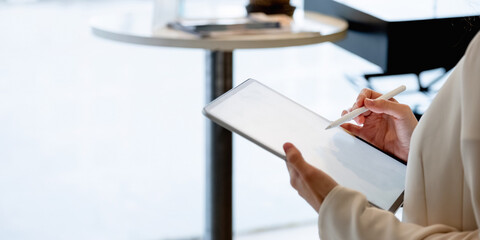 Close uo businesswoman holds pen stylus drawing on digital tablet on workplace