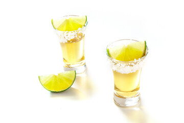 Tequila shots with lime slices on white