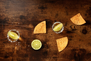 Tequila with lime and nacho chips, overhead flat lay shot