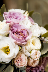 Bridal bouquet with purple and white flowers and rings
