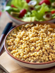 Boiled Ptitim or Birdy, Israeli pasta couscous with salad