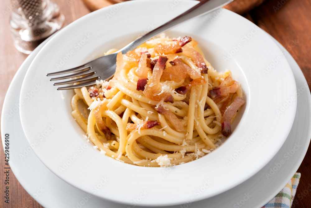 Wall mural piatto di deliziosi bucatini alla carbonara, cucina italiana