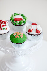 Seasonal festive christmas mini dessert cupcakes in traditional red green decorative symbols elements