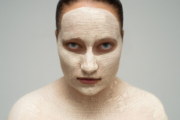 Spa girl applying facial mask. Beauty treatments. Close-up of a girl with cosmetic clay on her face. Gentle facial skin care. Spa 