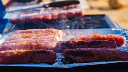 Sausages meat grilling on gas grill
