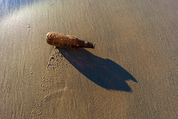empty bottle in the sand of the seaside
