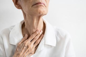 Asian senior patient touching neck with her hand,old elderly has sore throat,foreign body stuck in throat,painful swallowing,pain cough,inflammation of the larynx,throat problems or laryngitis disease - obrazy, fototapety, plakaty