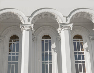 Corinthian columns and long windows. Public building. Ancient Greek temple. White classic columns.