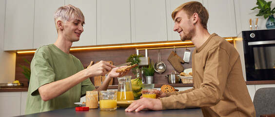 Smiling same-sex male pair eating during date