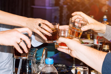 People holding glasses making a toast. Group of friends toasting and cheer glasses, drinking at bar. People with party cocktails. Birthday, celebration concept.