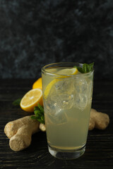 Glass of ginger - lemon drink and ingredients on wooden table