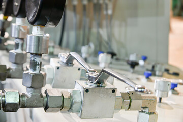Pressure gauges on hydraulic oil station with high pressure transfer tubes.