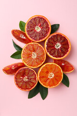 Red oranges and leaves on pink background