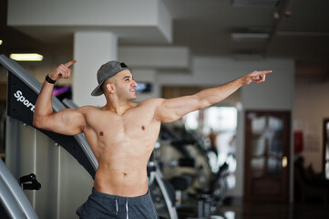 Fit and muscular arabian man posing in gym.