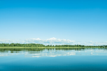 The beautiful landscape of big blue lake with reflection. Sunny summer day.