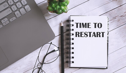 TIME TO RESTART text on the notebook with office background