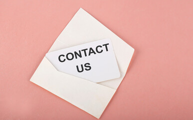 Word Writing Text CONTACT US on card on pink background