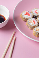 Sushi set in plate on pink background