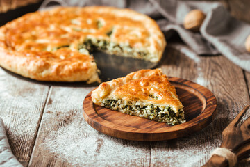 Side view on spinach filling pie on the wooden rustic table