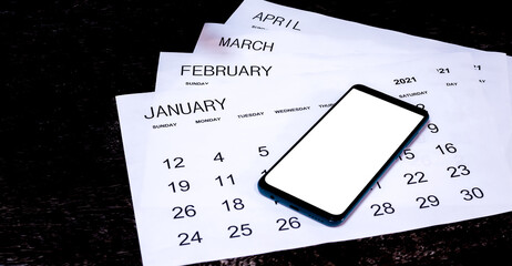 calendars and smartphones on a dark wooden table are a creative concept.