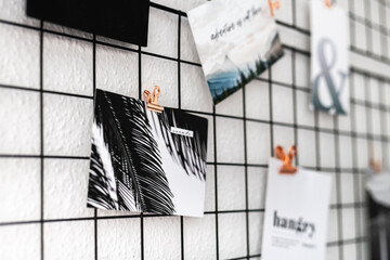 Postkarten mit Fotos und Typografie an einer Pinnwand befestigt mit metallklammern | Büro,...