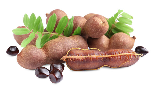 Delicious ripe tamarinds with leaves and seeds on white background. Exotic fruit