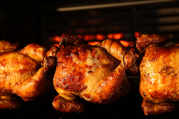 Grilling whole chickens in rotisserie machine, closeup © New Africa