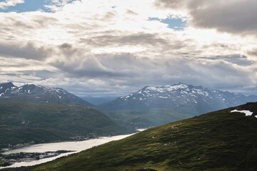 Scenic view of sea and mountains during a cloudy sunset in Tromso