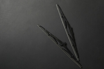 Car windshield wipers on black background, flat lay. Space for text - obrazy, fototapety, plakaty