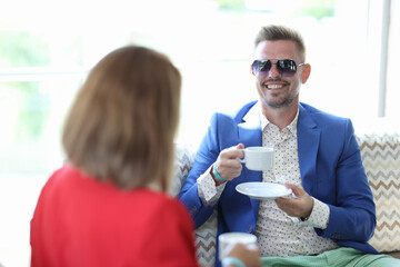 Businesswoman and businessman drink coffee in cafe