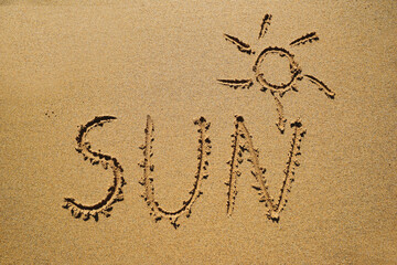The sun - an inscription on the sand by the ocean.