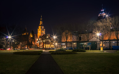 a night shot of the path leading to illuminated old buildings in Szczecin