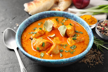 Bowl of delicious chicken curry on black table