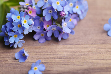 Beautiful blue Forget-me-not flowers on wooden table, closeup