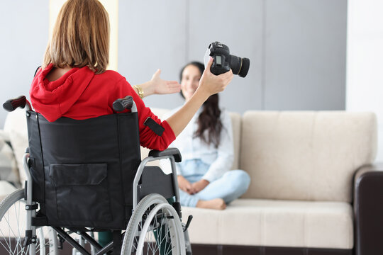 Woman in wheelchair with camera conducts home photo session